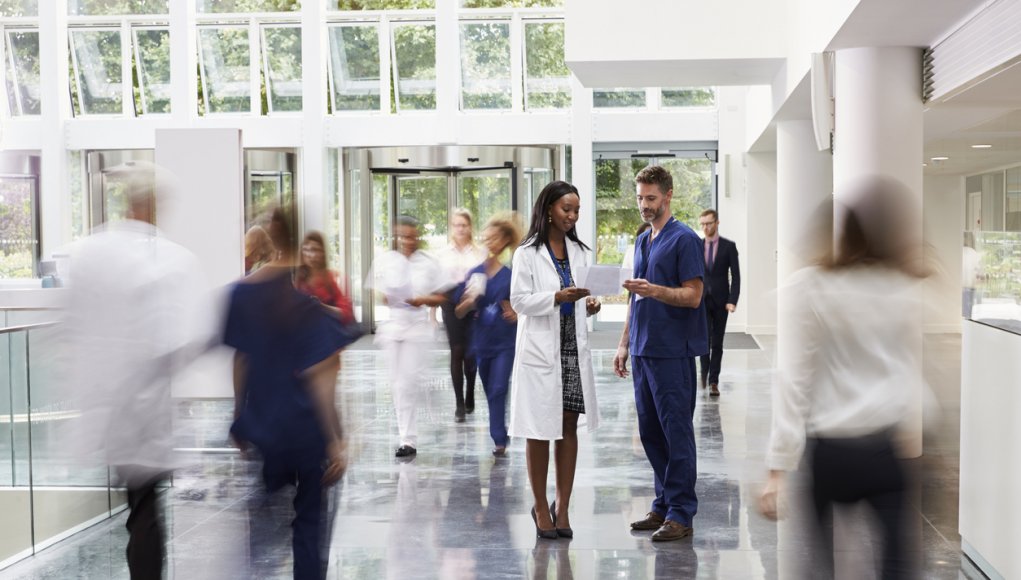 Staff In Busy Lobby Area Of Modern Hospital