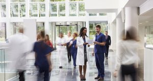 Staff In Busy Lobby Area Of Modern Hospital