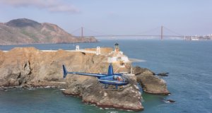 Aerial view of a helicopter flying past the Point Bonita Lighthouse at the entrance into the San Francisco Bay on a sunny day, California, USA.