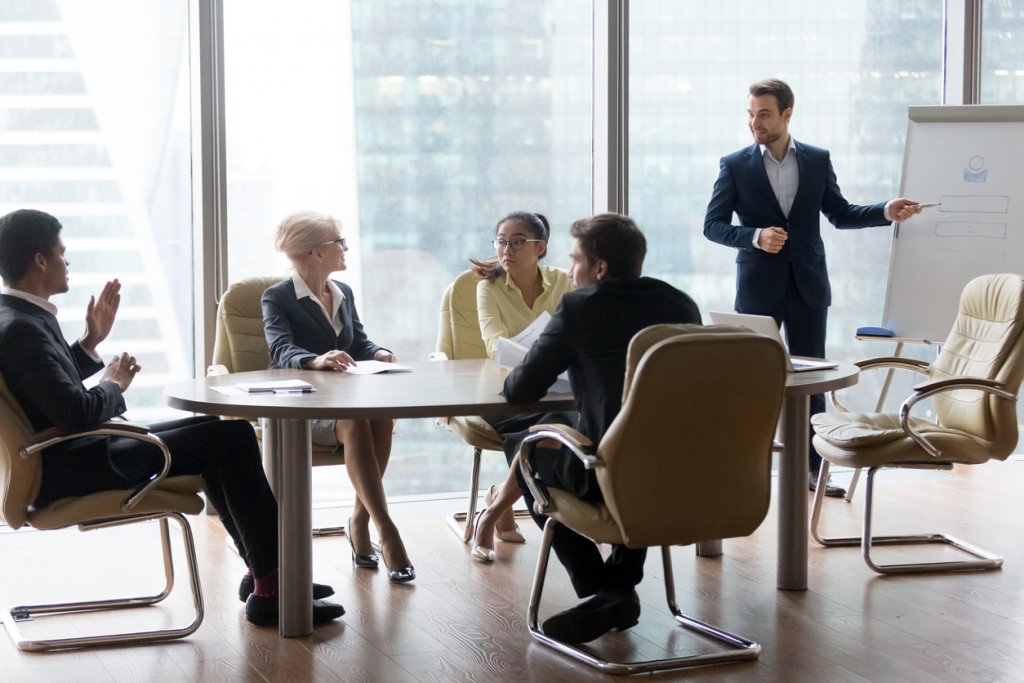 African man raising hand to ask question. Boss leader businessman presenting new project to multiracial employees colleagues during briefing Corporate training and coaching, conference seminar concept