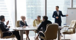 African man raising hand to ask question. Boss leader businessman presenting new project to multiracial employees colleagues during briefing Corporate training and coaching, conference seminar concept