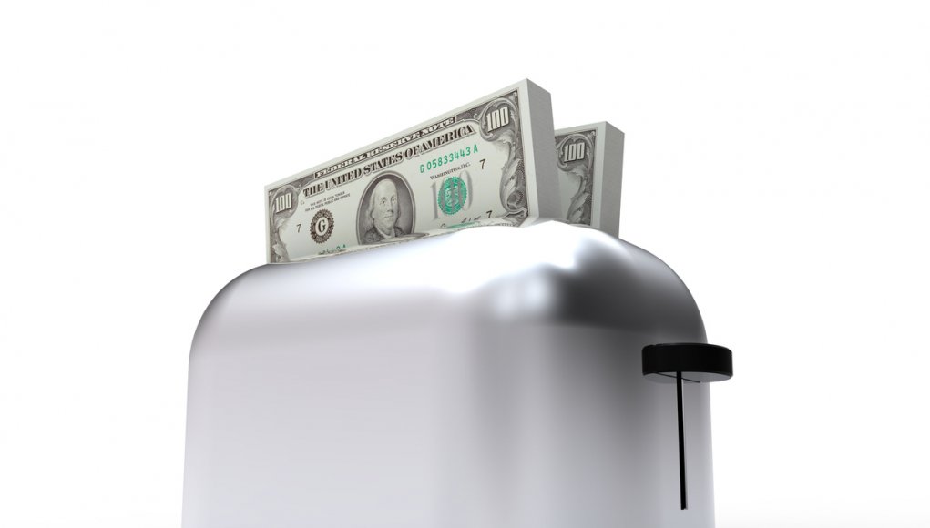 A toaster machine (for bread) with money emerging from it