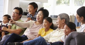 Extended Family Group At Home Watching TV Together