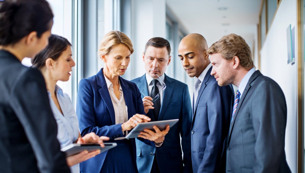 Businesswoman with digital tablet and team of associates