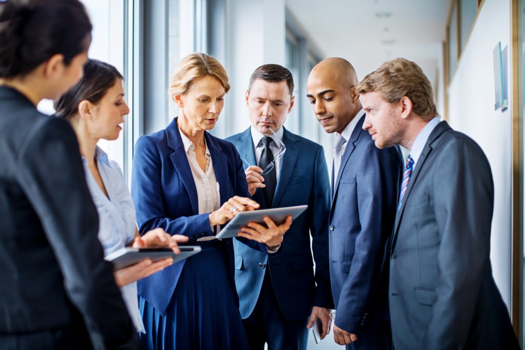 Businesswoman with digital tablet and team of associates