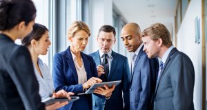 Businesswoman with digital tablet and team of associates