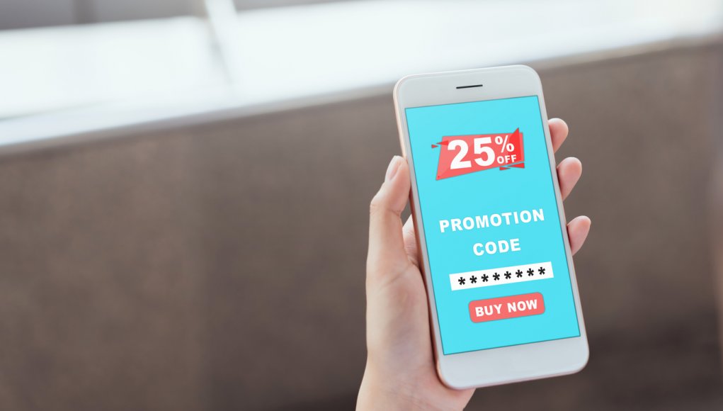 Holding the smartphone to enter the code to get a discount from the store. The concept of providing marketing services on the internet for easy access to information.