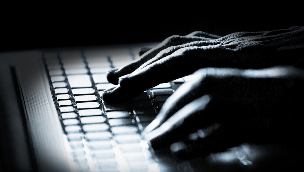 Hacker! Concept photo in high contrast black and white of hacker's fingers on keyboard