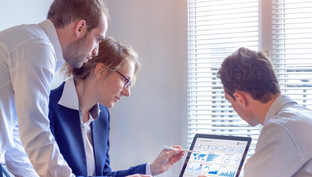 CDO examining numbers on a computer screen with colleagues