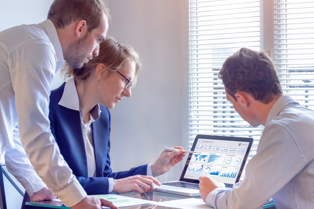 CDO examining numbers on a computer screen with colleagues