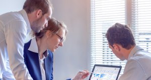 CDO examining numbers on a computer screen with colleagues