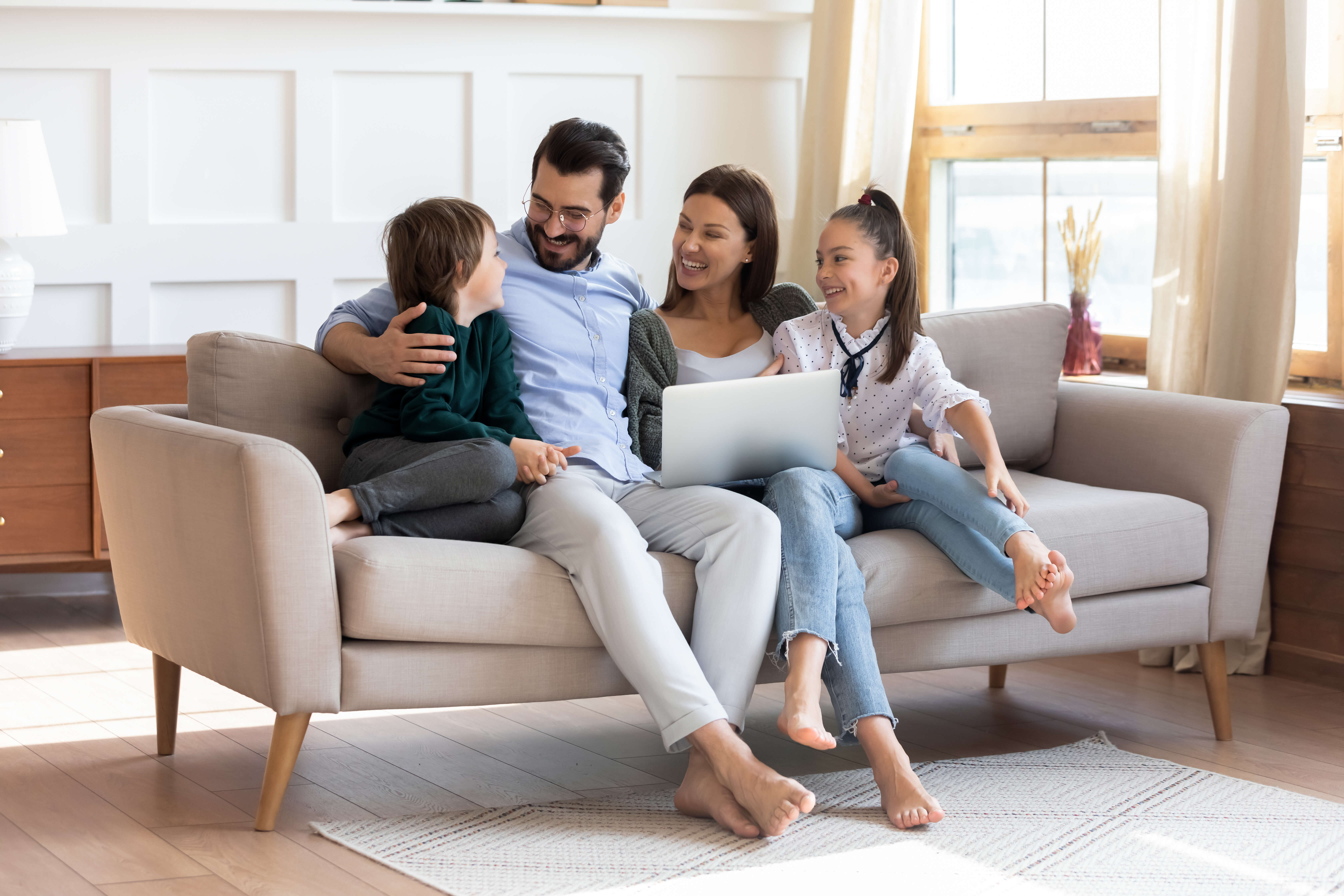 Family of four watching movie on laptop