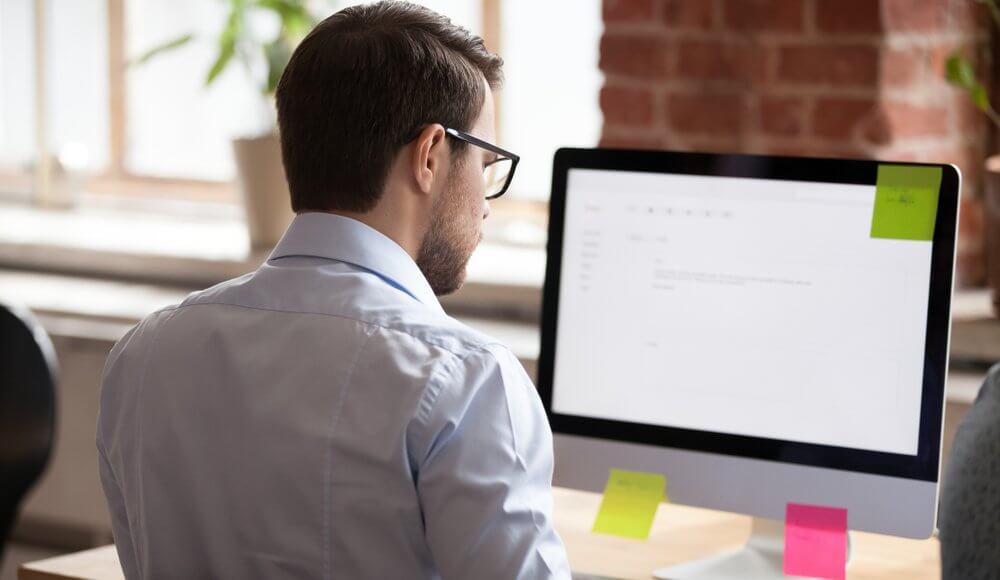 Person reading email on computer, looking at fake Amazon cancellation email