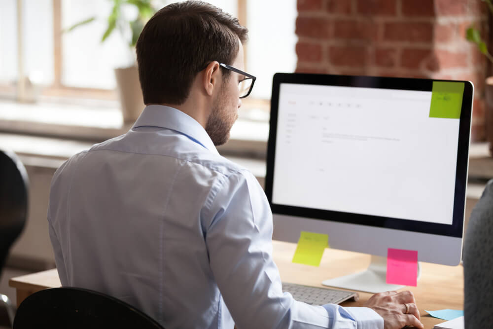 Person reading email on computer, looking at fake Amazon cancellation email