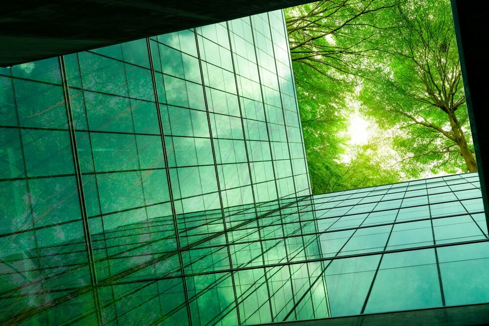 Eco-friendly building with tree branches concept; ESG goals and technology, cyber security 2023