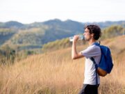 Man walking on Italian hillside, drinking water