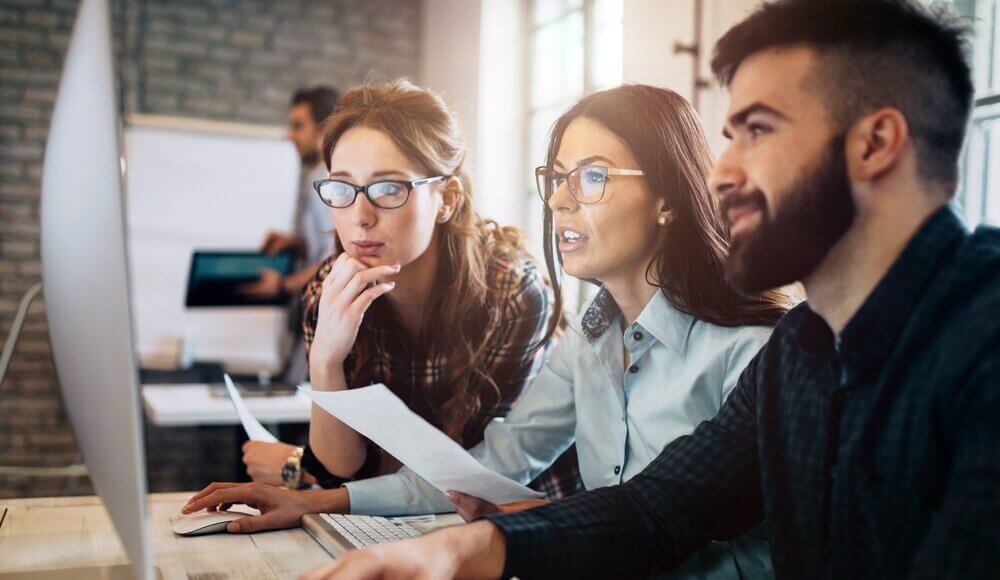 Information technology professionals looking at a computer