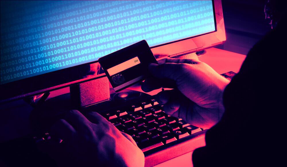 Hackers' hands reading a credit card