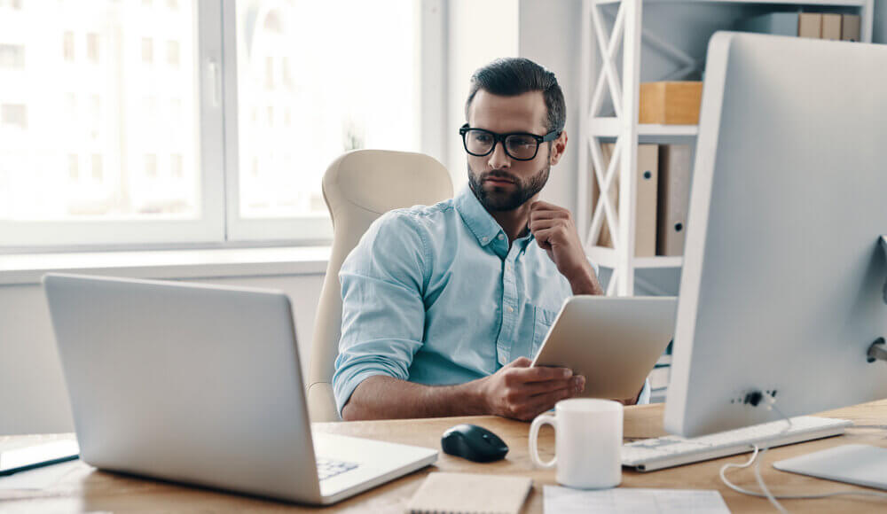 Innovative young business man at desk, achieving more with less, cyber security spending