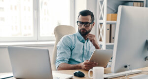 Innovative young business man at desk, achieving more with less, cyber security spending