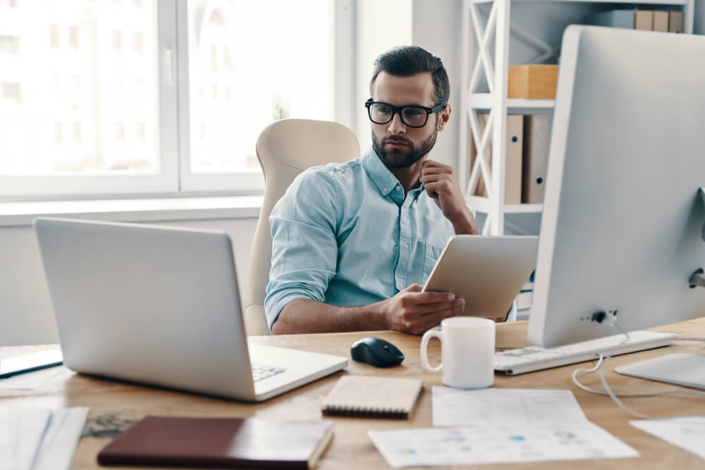 Innovative young business man at desk, achieving more with less, cyber security spending