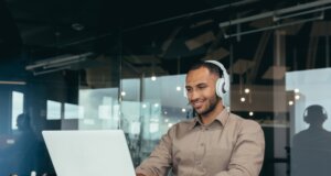 Young tech guy listening to music while working