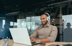 Young tech guy listening to music while working