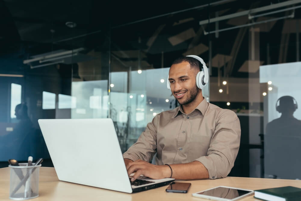 Young tech guy listening to music while working