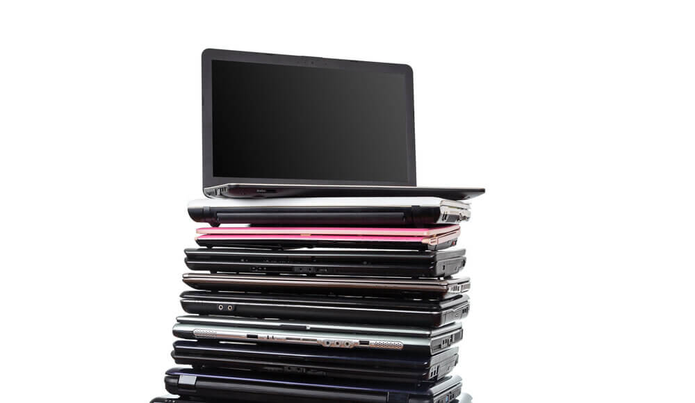 Stack of laptops in various colors and models