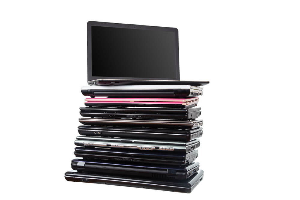 Stack of laptops in various colors and models