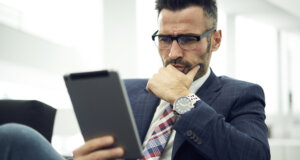 Portrait of a mindful business person reading something on a Tablet device