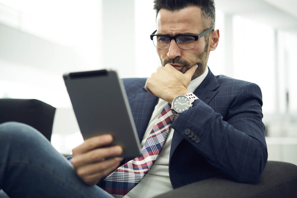 Portrait of a mindful business person reading something on a Tablet device