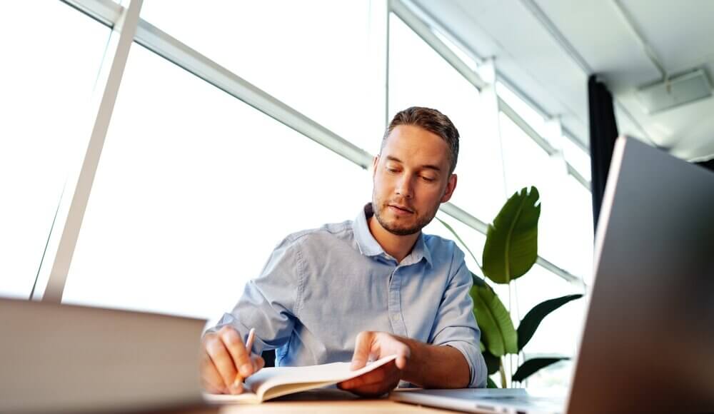 Man sitting at desk studying for CISO certification; CISO certification path concept art