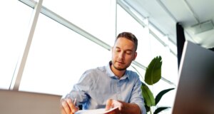 Man sitting at desk studying for CISO certification; CISO certification path concept art