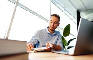 Man sitting at desk studying for CISO certification; CISO certification path concept art