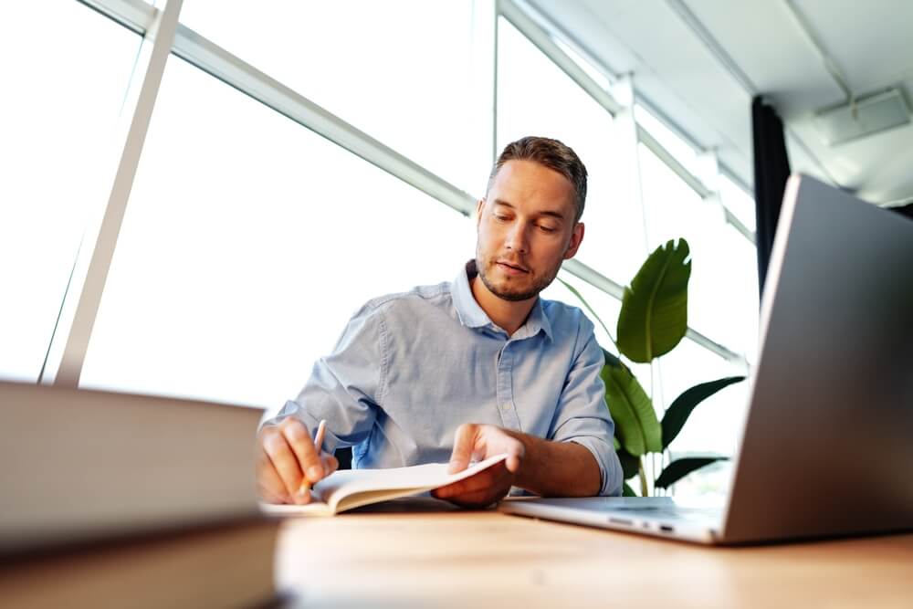 Man sitting at desk studying for CISO certification; CISO certification path concept art